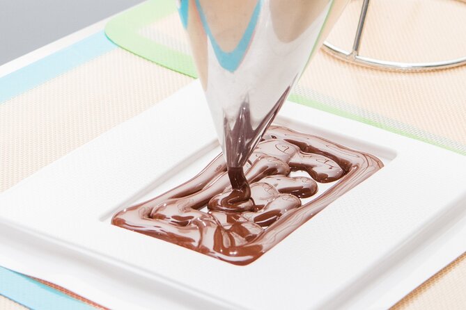 Warm chocolate spread across a marble tempering slab